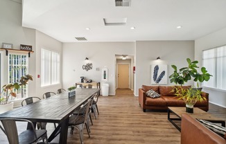 a living room and dining room with a long wooden table and chairs