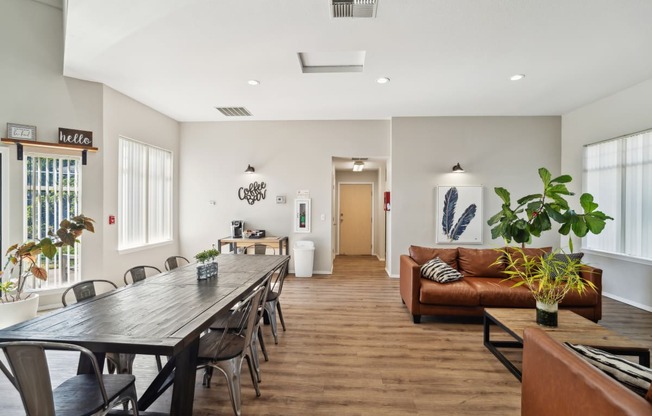 a living room and dining room with a long wooden table and chairs