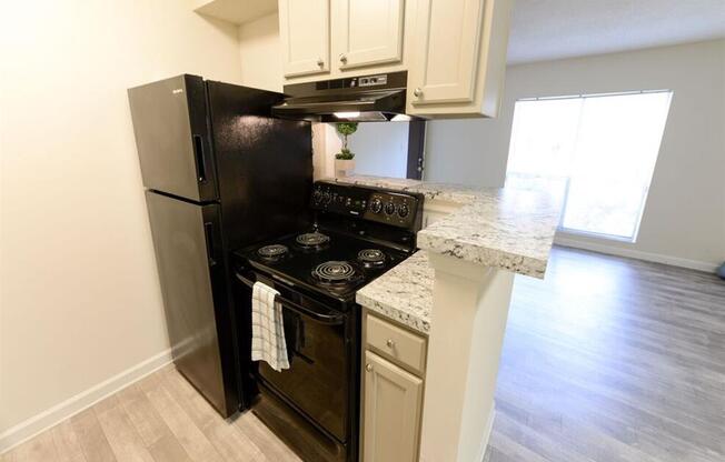 Spacious kitchen with white cabinets and black appliances at the Grove at St. Andrews, Columbia, SC