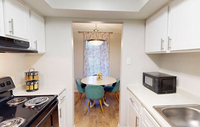 A kitchen with white cabinets and a black stove top oven.