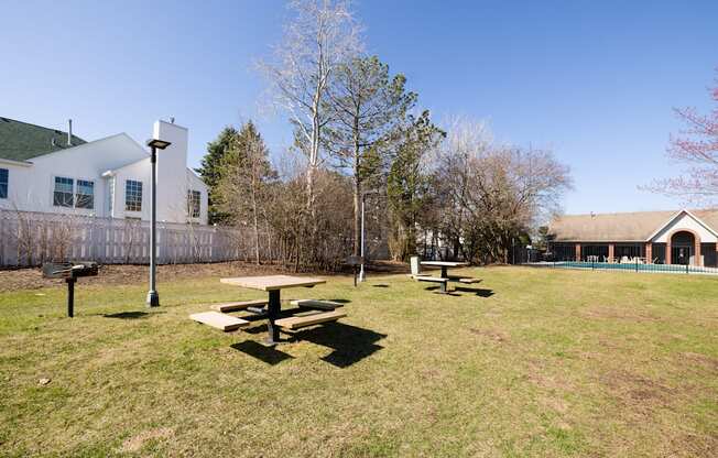 A picnic table sits in the middle of a grassy field.