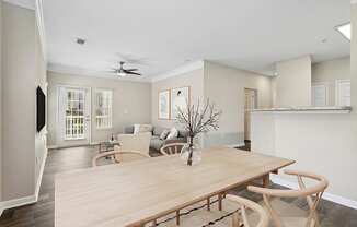 a living room and dining room with a wooden table