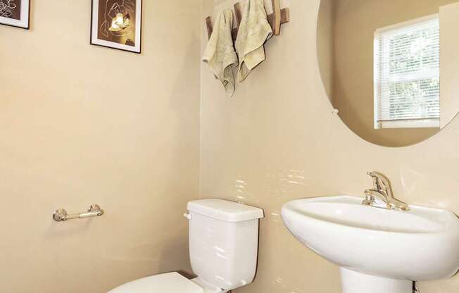 A white toilet and sink in a bathroom at The Landing Apartments and Townhomes, Oregon, 97045