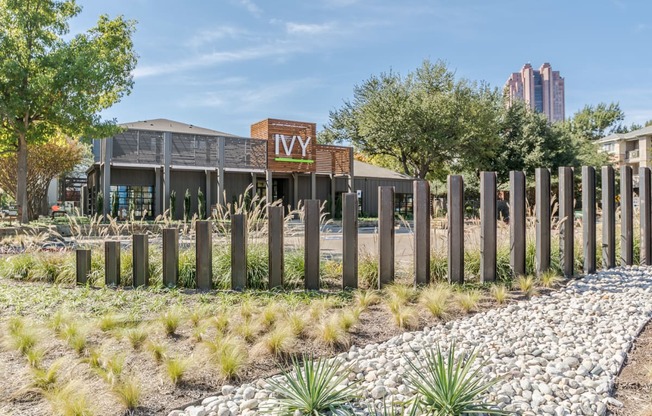 a view of the front of the building with a fence in the foreground and a building in