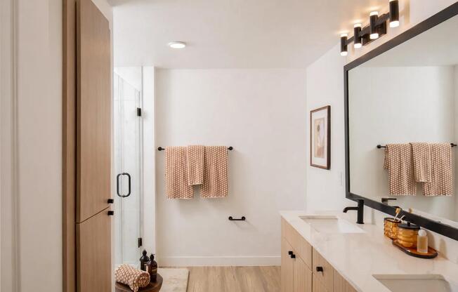 A refined primary bath with warm wood cabinetry, matte black fixtures, and clean lines for a polished, everyday routine.
