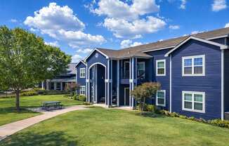 A blue building with a tree in front of it.