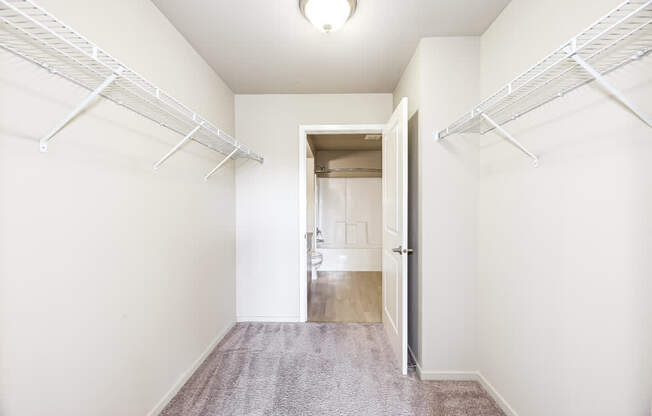 A hallway with white walls and a carpeted floor.