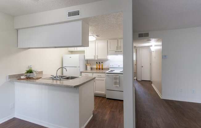 This is a photo of the kitchen and hallway from the dining room in the 871 square foot 2 bedroom, 2 bath apartment at Princeton Court Apartments in the Vickery Meadow neighborhood of Dallas, Texas.