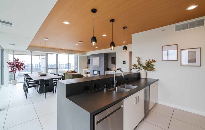 A modern kitchen with a large island and pendant lights.