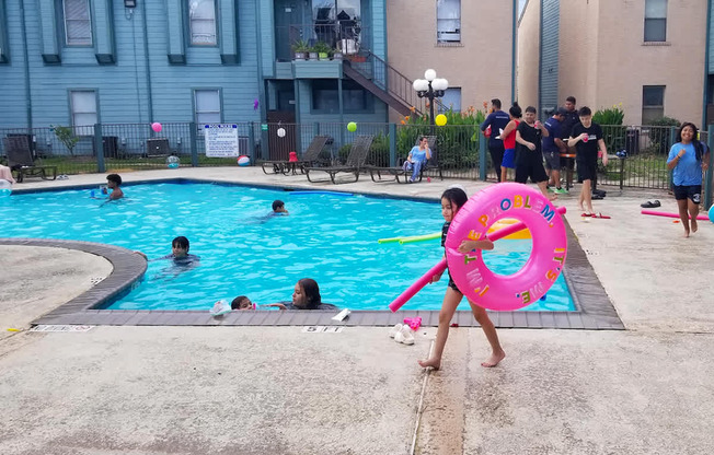 A person is holding a pink inflatable ring at a pool party