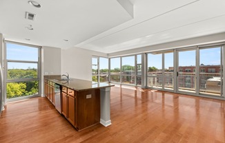 a living room with a large window and a kitchen with a counter top