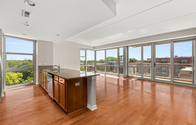 a living room with a large window and a kitchen with a counter top