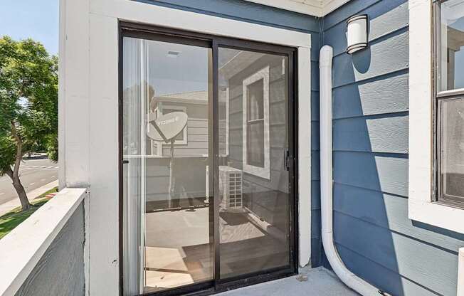 A blue house with a glass door and a sign that says "Welcome".