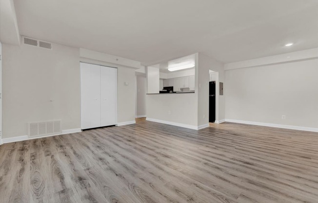 a bedroom with hardwood floors and white walls