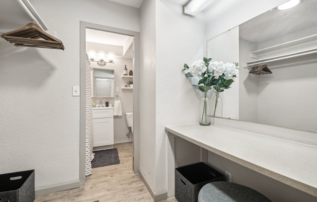 a bathroom with a mirror and a vase with white flowers