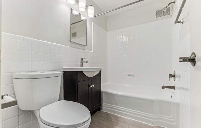 A white bathroom with a toilet, sink, and bathtub.