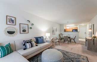 A living room with a couch, a table, and a mirror.