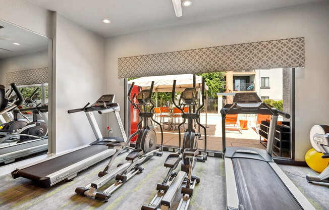 Community Fitness Center with Equipment and Mirrors at Harmony at Surprise Apartments in Surprise, AZ.