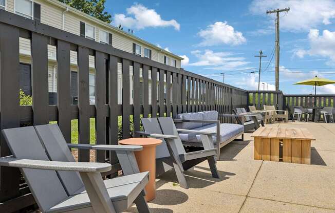 A row of grey chairs are lined up on a patio.