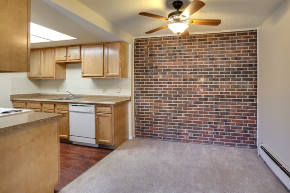 a kitchen with a brick wall and wooden cabinets