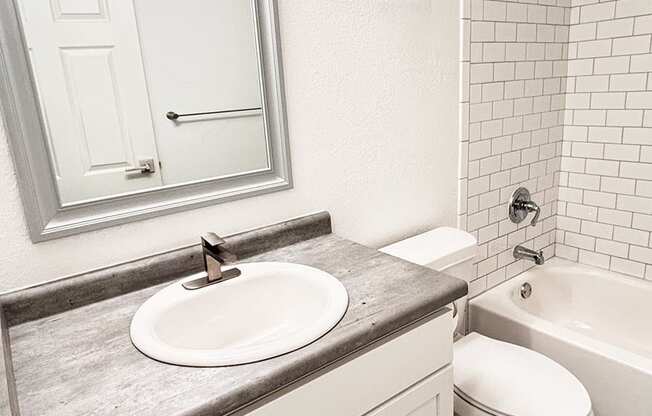 A bathroom with a sink, toilet, and bathtub.