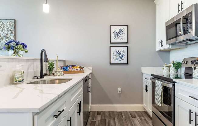 A kitchen with a white counter top and a sink.