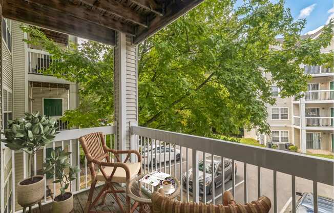 a porch with two chairs and a table on a balcony at Sanger Place, Lorton, VA