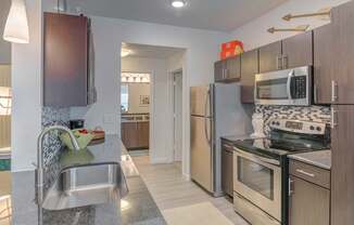 A modern kitchen with stainless steel appliances and wooden cabinets.