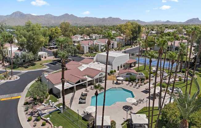 A view of a resort with a pool and palm trees.
