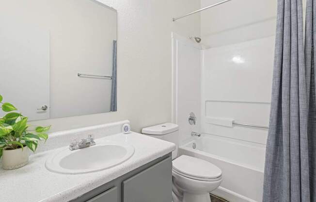 Pet-Friendly Apartments in Austin, TX – Huntington Meadows – A white bathroom with a sink, toilet, and bathtub.