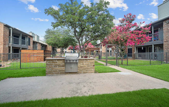an outdoor barbecue area at the whispering winds apartments in pearland, tx