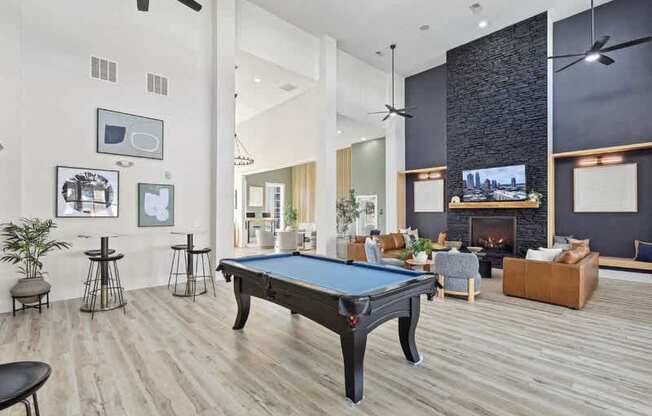 A pool table is in the middle of a room with a fireplace and a TV.