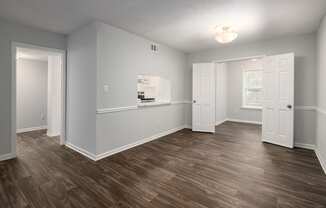 an empty living room with wood flooring and white walls