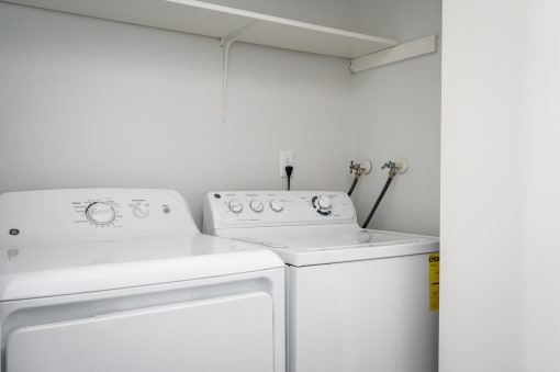 an empty laundry room with two washes and a dryer