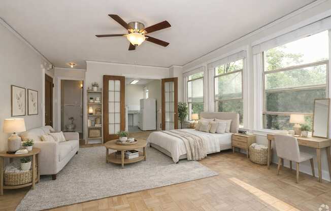 A well-lit, spacious bedroom with a large bed, a desk, and a couch.