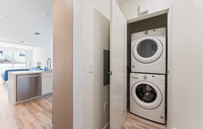 a front loading washer and dryer in a laundry room with a door to