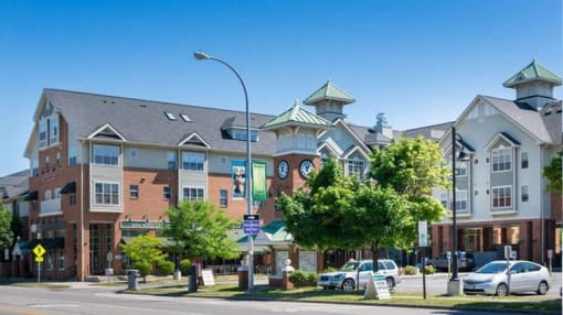 View of Corn Hill Landing from Exchange Boulevard showing street-level shops and restaurants as well as apartments above and entryway clock tower