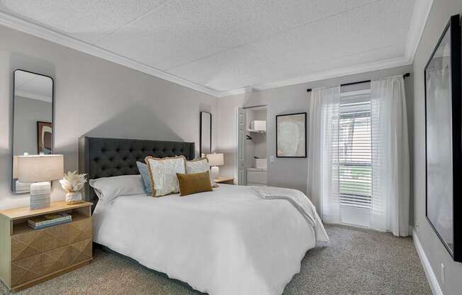 A bedroom with a large bed and a dresser with a mirror.