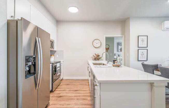 a kitchen with white quartz countertops and stainless steel appliances