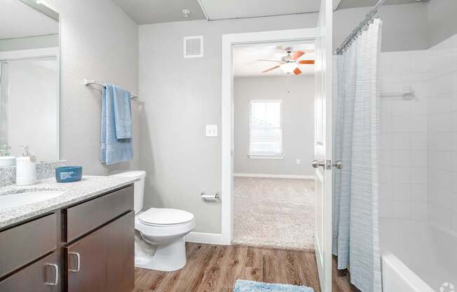 A bathroom with a toilet, sink, and a fan.