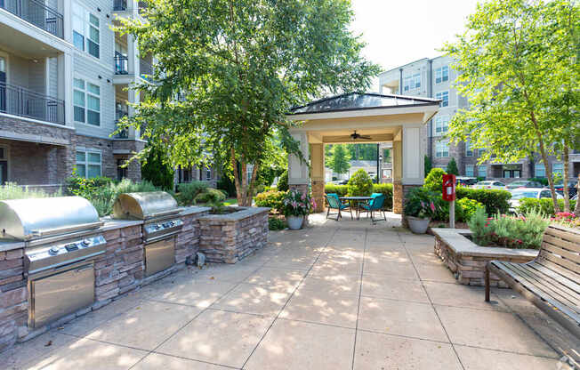 A patio with a gazebo, benches, and a fire pit.