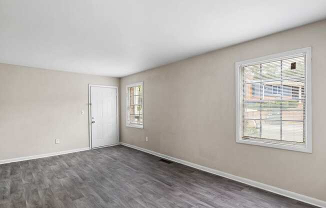 the living room of an apartment with a window and a door