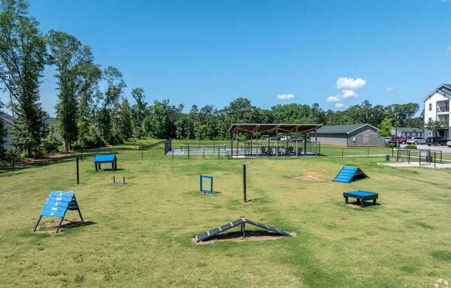 A park with a playground and a building in the background.