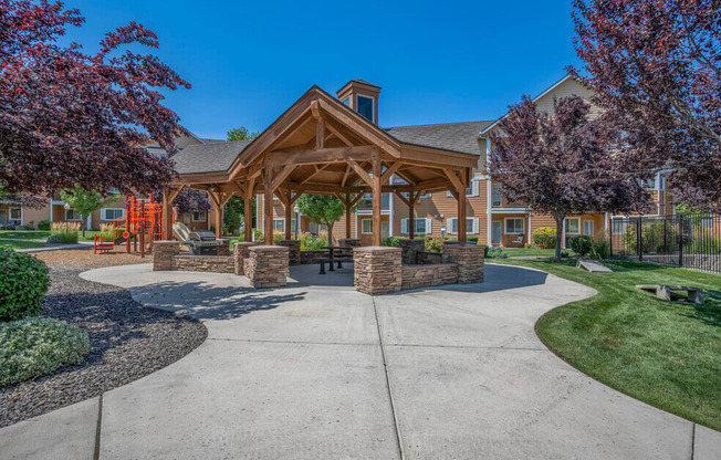 A large wooden building with a porch and a stone wall in front.