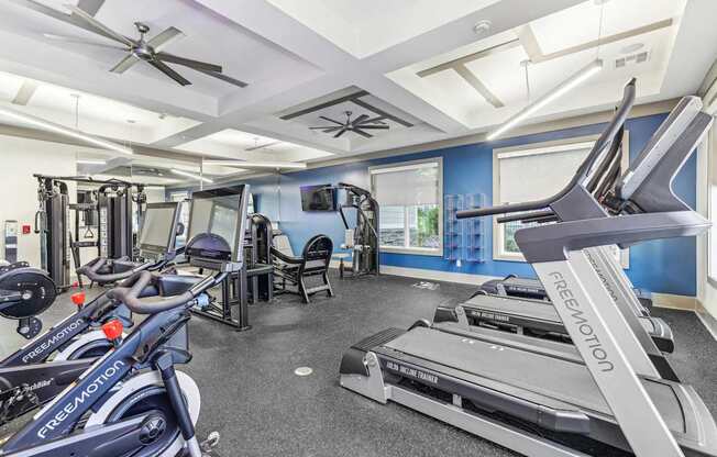 A gym with treadmills, elliptical machines, and other exercise equipment.