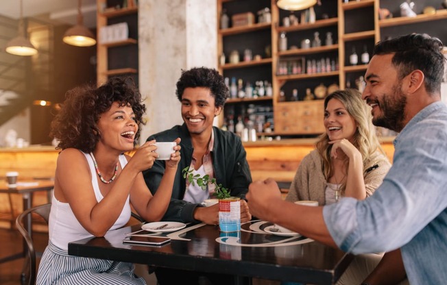 a group of people sitting around a table in a restaurant