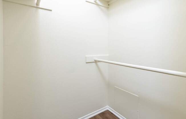A white wall with a corner and a white baseboard.