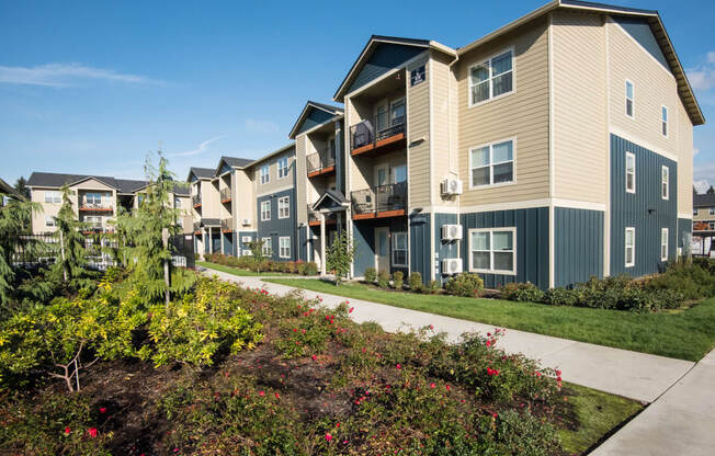 an exterior view of a row of apartment buildings with a sidewalk