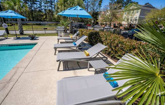 a group of lounge chairs next to a swimming pool