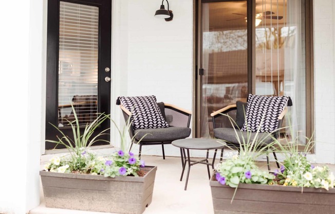 a patio with two chairs and a coffee table